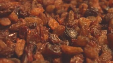 Bej (doku tablo yüzeyi) arka plan üzerinde kuru üzüm. 2 atış. Yavaş çekim. Yatay kaydırma. Close.