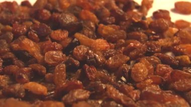 Bej (doku tablo yüzeyi) arka plan üzerinde kuru üzüm. 2 atış. Yavaş çekim. Yatay kaydırma. Close.