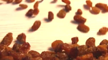 Bej (doku tablo yüzeyi) arka plan üzerinde kuru üzüm. 2 atış. Yavaş çekim. Dikey tava. Close.
