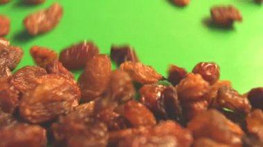 Yeşil arka planda kuru üzüm. 2 atış. Yavaş çekim. Yatay kaydırma. Close.