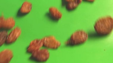 Yeşil arka planda kuru üzüm. 2 atış. Yavaş çekim. Yatay kaydırma. Close.