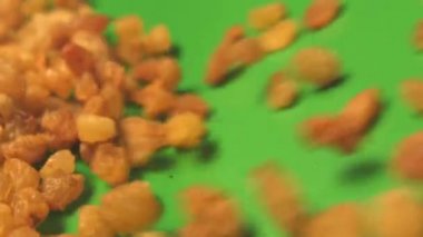 Yeşil arka planda kuru üzüm. 2 atış. Dikey tava. Yavaş çekim. Close.