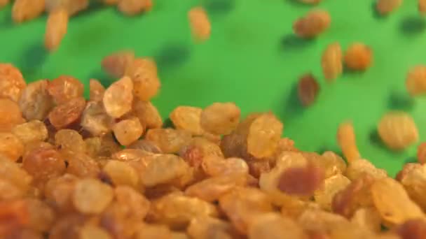 Raisins on a green background. 2 Shots. Close-up. Slow motion — Stock Video