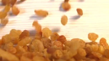 Bej (doku tablo yüzeyi) arka plan üzerinde kuru üzüm. Yavaş çekim. 2 Shots.Dikey tava. Close.