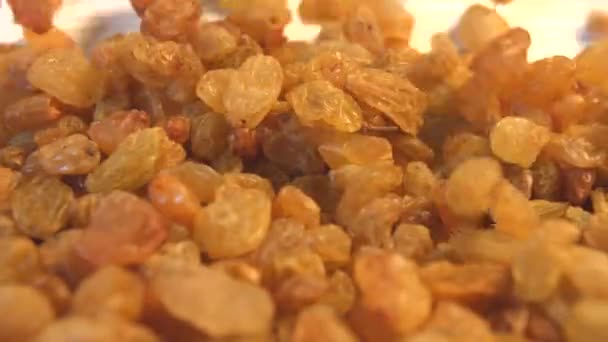 Raisins on a beige (texture table surface) background. Slow motion. 2 Shots.Vertical pan. Close-up. — Stock Video