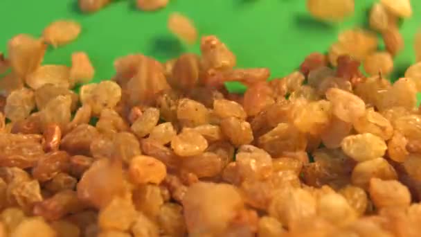 Raisins on a green background. 2 Shots. Vertical pan. Slow motion. Close-up. — Stock Video
