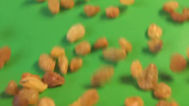 Raisins on a green background. 2 Shots. Horizontal pan. Slow motion. Close-up. — Stock Video