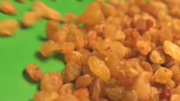 Raisins on a green background. 2 Shots. Slow motion. Horizontal pan. Close-up. — Stock Video