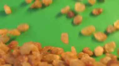 Yeşil arka planda kuru üzüm. Yavaş çekim. 2 atış. Yatay kaydırma. Close.