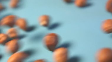 Mavi bir arka plan üzerinde fındık. Dikey pan. 2 tekila. Yakın çekim.