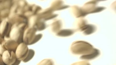 Beyaz zemin üzerine Antep fıstığı. 2 tekila. Yatay pan. Yakın çekim.