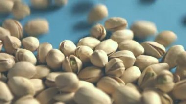 Mavi bir arka plan üzerine Antep fıstığı. 2 tekila. Yatay pan. Yakın çekim.