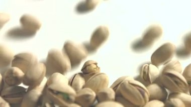 Beyaz zemin üzerine Antep fıstığı. 2 tekila. Yatay pan. Yakın çekim.