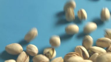 Mavi bir arka plan üzerine Antep fıstığı. 2 tekila. Dikey pan. Yakın çekim.