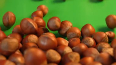 Fındık yeşil bir arka plan üzerinde. 2 tekila. Ağır çekim. Yatay pan. Yakın çekim.