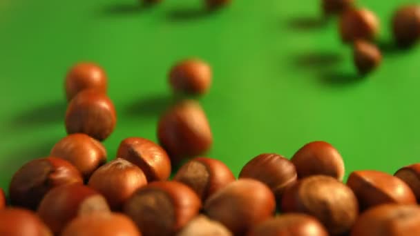 Hazelnuts on a green background. 3 Shots. Horizontal pan. Close-up. — Stock Video