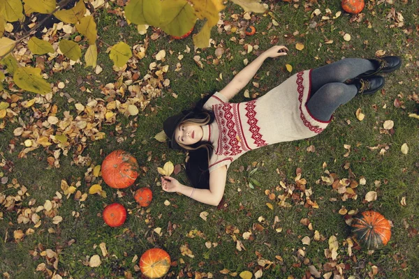 カボチャの女の子 美しい女性が芝生の上に横たわっている 最上階だ 彼女はカボチャの近くにある — ストック写真