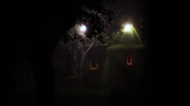 Peri evi ve tuhaf bir adam. Adam eve doğru yürür ve onun önünde durur. Evin arka planında erkek siluetleri var..