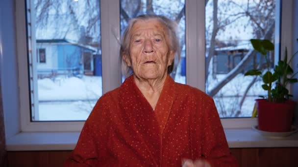 Nagymama Orvosi Maszkban Egy Öreg Nagymama Otthon Ott Áll Ablaknál — Stock videók