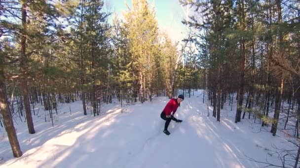 在冬天的森林里热身和慢跑 2发子弹 导言慢跑前 一个人伸展他的腿 脊椎和肩膀 他沿着一条雪地的森林小路奔跑 — 图库视频影像