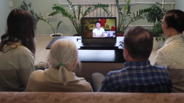 自宅からのビデオチャット自宅からのビデオリンクを介して5人が通信します ソファに座っている家族もいます 彼らはラップトップを使用して親戚や知人と通信します — ストック動画