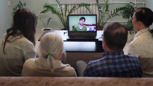 自宅からのビデオチャット自宅からのビデオリンクを介して5人が通信します ソファに座っている家族もいます 彼らはラップトップを使用して親戚や知人と通信します — ストック動画