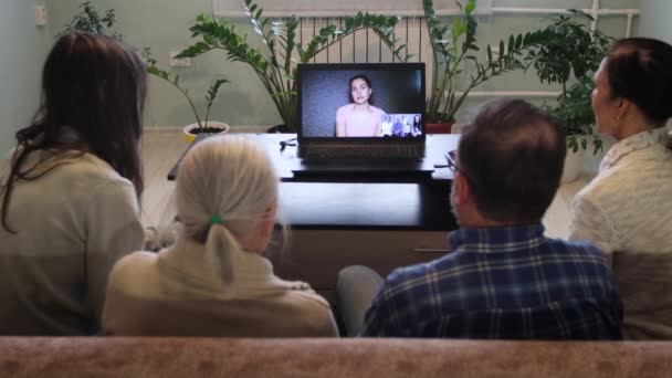 家からのビデオチャット 5人が自宅からのビデオリンクを介して通信します ソファに座っている家族もいます 彼らはラップトップを使用して親戚や知人と通信します — ストック動画