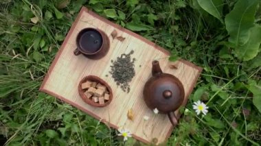 Doğada çay. Düz yatıyordu. Bambu peçetesinde kurutulmuş yeşil çay. Ayrıca küçük bir sepetinde kamış şeker küpleri var..
