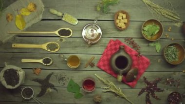 Eski ahşap bir masada çay. Düz yatıyordu. Değişik çay türleriyle yaşam: siyah, yeşil, eş, amber çiçeği, meyve, bitkisel.