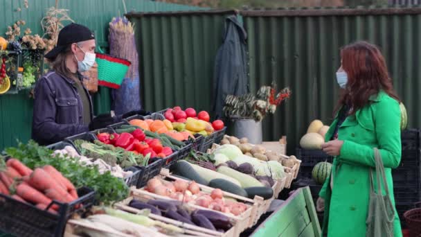 시장에서 호박을 농산물 직판장에서 아름다운 호박을 판매자는 호박을 가방에 넣는다 — 비디오