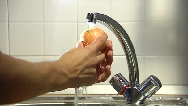 Les mains lavent la pomme sous l'eau courante. 2 clichés . — Video