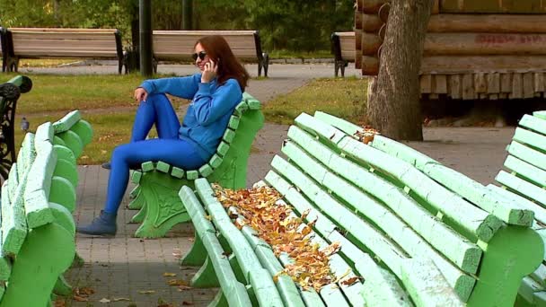 Menina no parque falando ao telefone . — Vídeo de Stock