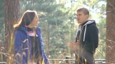 Genç bir adam ve bir kadın parkta konuşuyor..