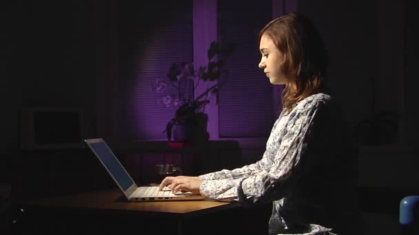 Junge Frau tippt auf einem weißen Laptop. Abend. — Stockvideo