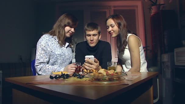 Hombre y dos mujeres mirando el teléfono inteligente . — Vídeos de Stock