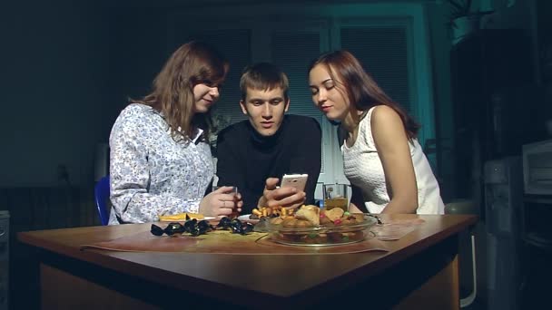 Hombre y dos mujeres mirando el teléfono inteligente . — Vídeo de stock