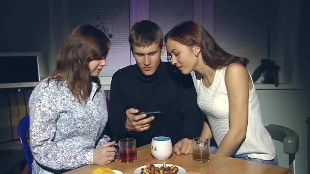 Homme et deux femmes regardant smartphone . — Video