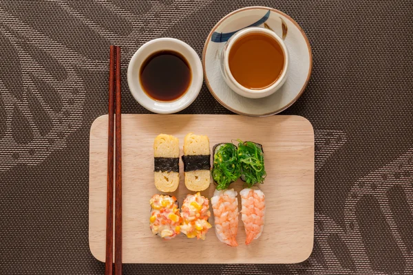 Sushi set met chop sticks en soja saus geserveerd op houten leisteen — Stockfoto