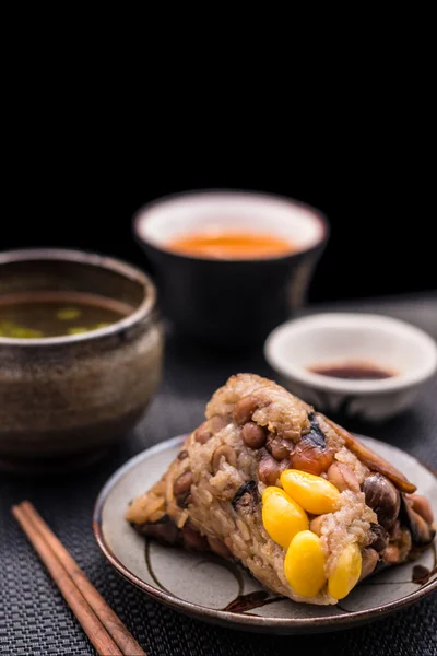 Zongzi o albóndigas de arroz pegajoso chino asiático con té amarillo —  Fotos de Stock