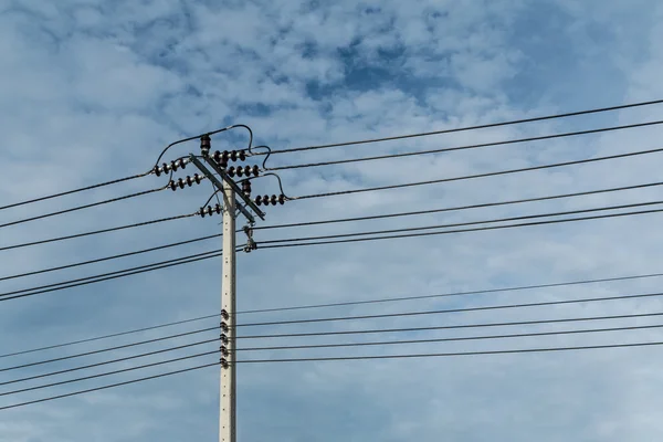 Poste eléctrico y línea de electricidad con contra el cielo azul nublado , —  Fotos de Stock