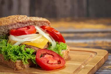 Peynirli, jambonlu, domatesli, salatalı, soğanlı sandviçi yakın çekim yap.. 