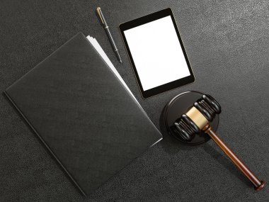 Wooden judges gavel and tablet computer on black leather desk