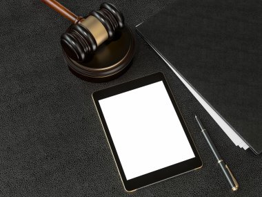 Wooden judges gavel and tablet computer on black leather desk