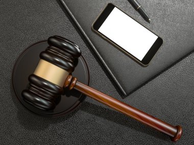 Wooden judges gavel and phone on black leather desk