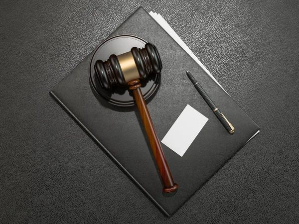 Wooden judges gavel and leather folder on black leather desk — Stockfoto