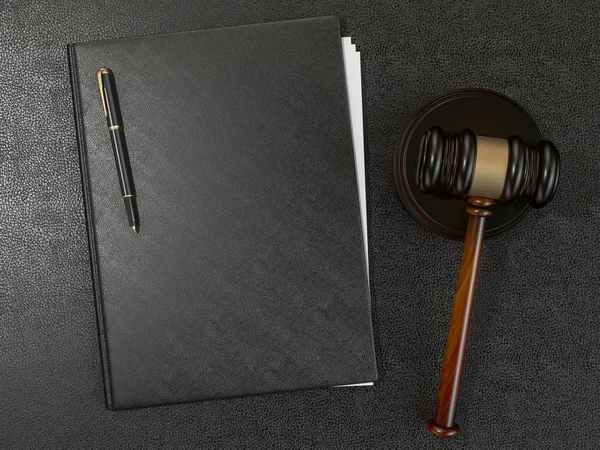 Wooden judges gavel and leather folder on black leather desk — Stockfoto