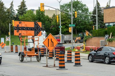 Londra, Ontario, Kanada - 12 Temmuz 2021: Yol yapımı trafik oku, işaret ve şerit kapanışını gösteren koniler.