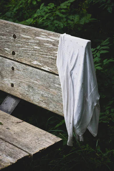 失われた女性の白いカーディガンセーターの選択的な焦点は ハイキングトレイルの木製のベンチに掛けました 悲しみと喪失の概念 — ストック写真