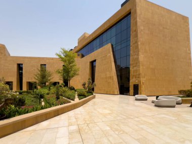 Riyad, Suudi Arabistan 'ın modern ticaret bölgesi. Suudi Arabistan 'ın Riyad kentindeki modern bir alışveriş ve ticaret bölgesinin çarpıcı manzarası. Mimari geometrik şekilleri, yeşilliği ve zarifliği harmanlıyor.
