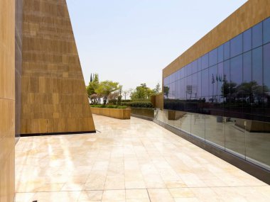 Riyad, Suudi Arabistan 'ın modern ticaret bölgesi. Suudi Arabistan 'ın Riyad kentindeki modern bir alışveriş ve ticaret bölgesinin çarpıcı manzarası. Mimari geometrik şekilleri, yeşilliği ve zarifliği harmanlıyor.